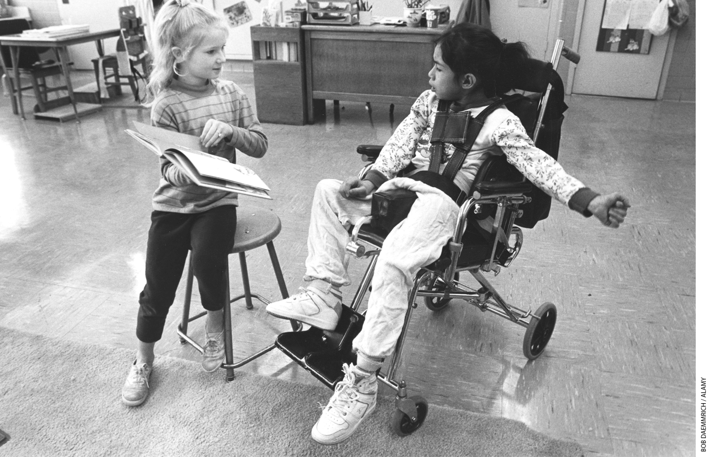 A 4th-grade student reads to a classmate with cerebral palsy at a public school in Austin, Texas, in 1988.