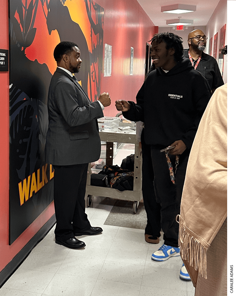 Executive Principal of Central Wake High School Thomas Hanley fist bumps a student in the hallway on his way to class.