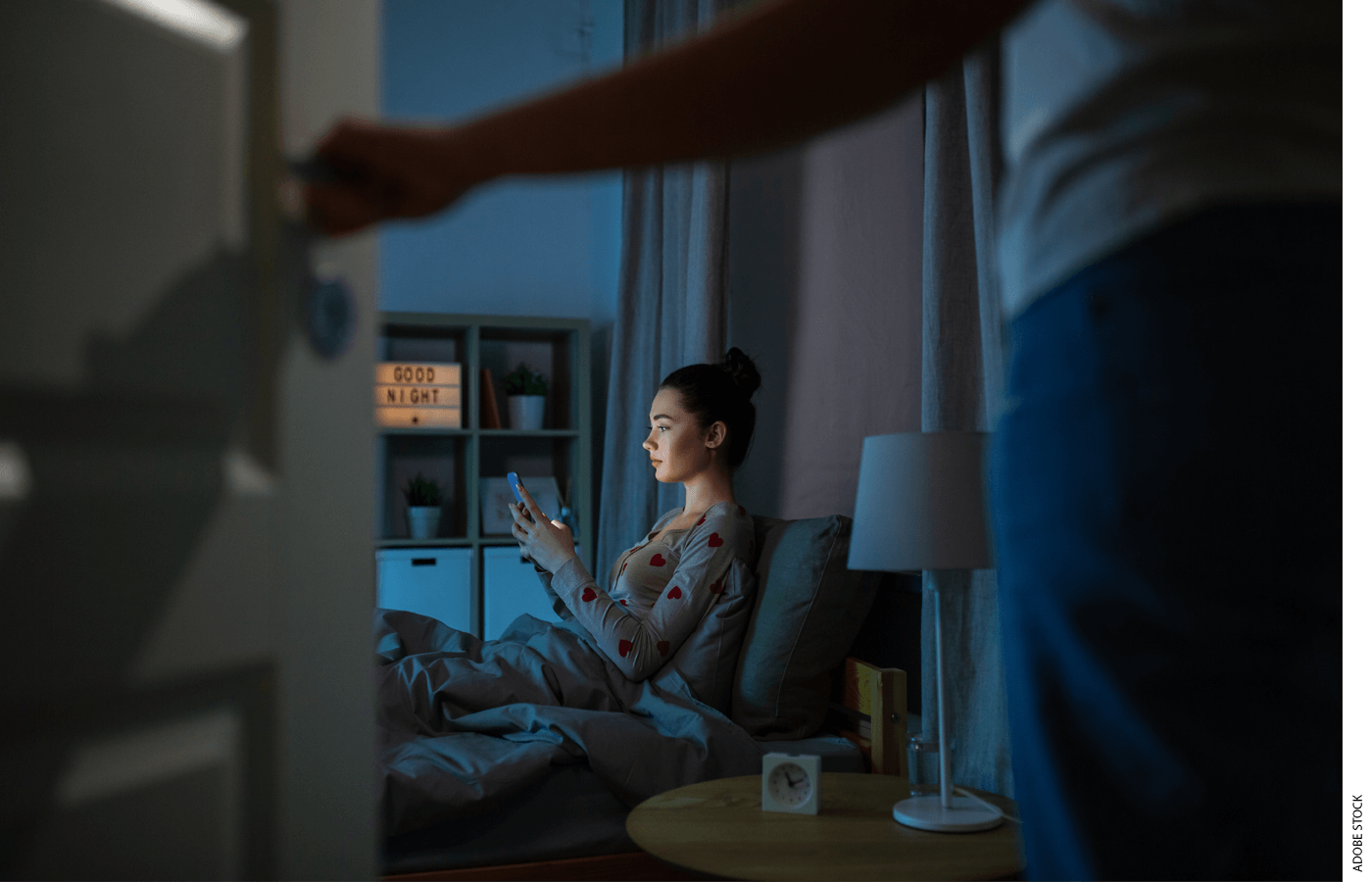 A student reads her phone in a dark room