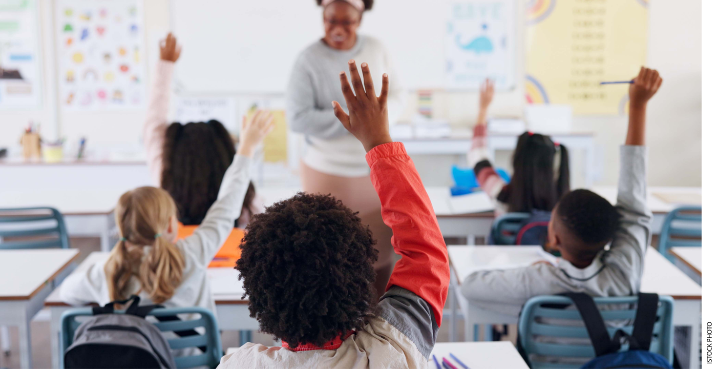 Photo of students raising their hands in class