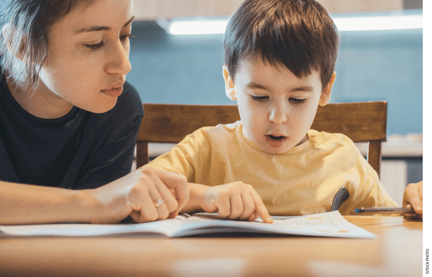 A teacher works with a student on reading