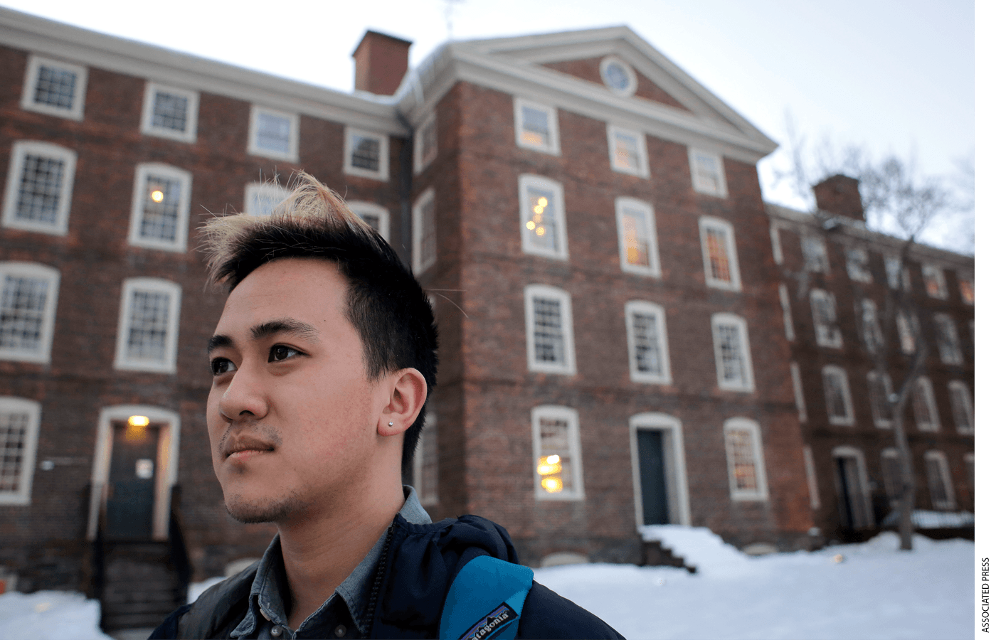A Vietnamese-American student stands in front of a university
