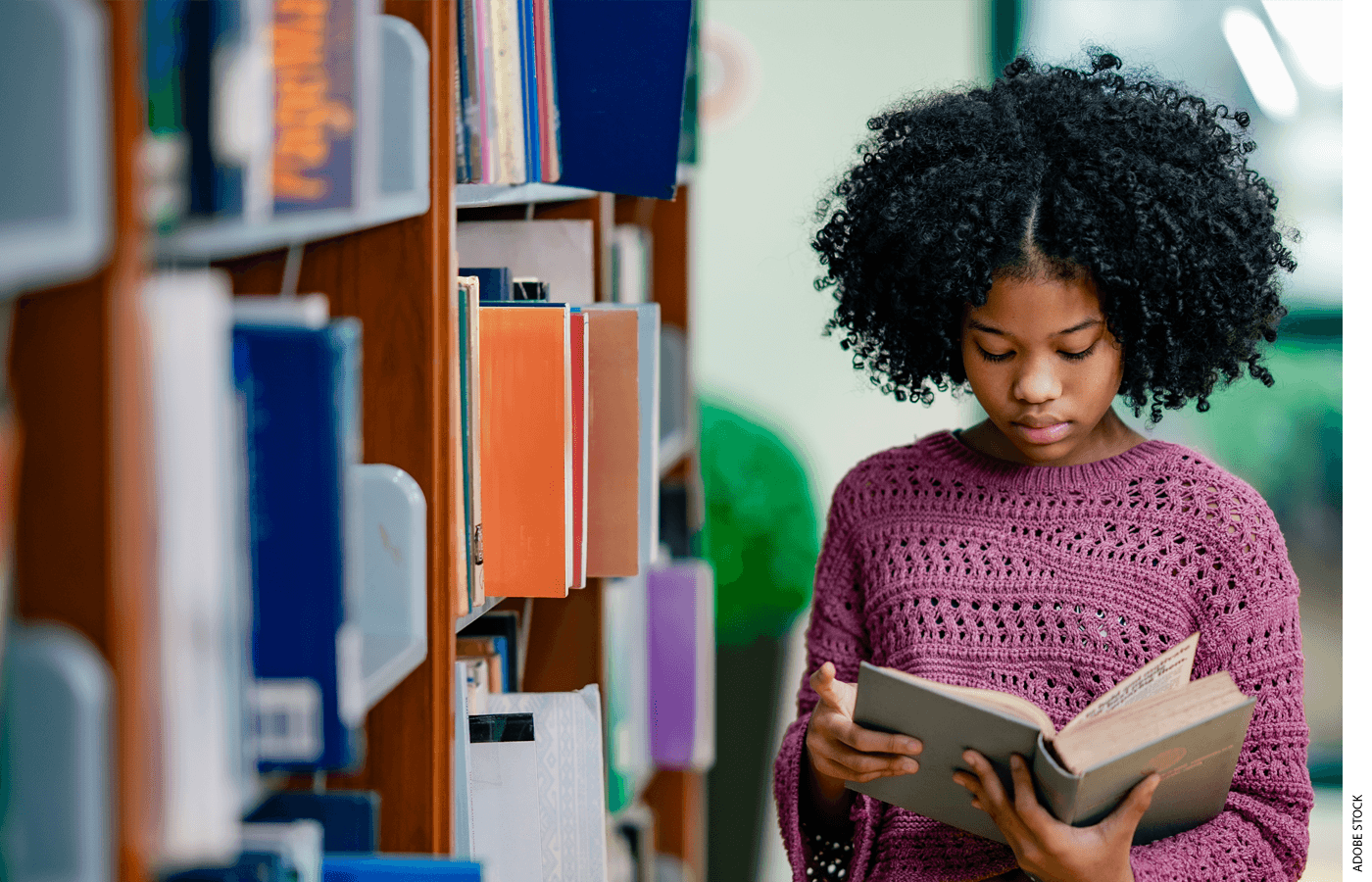 A student reads a book in a library