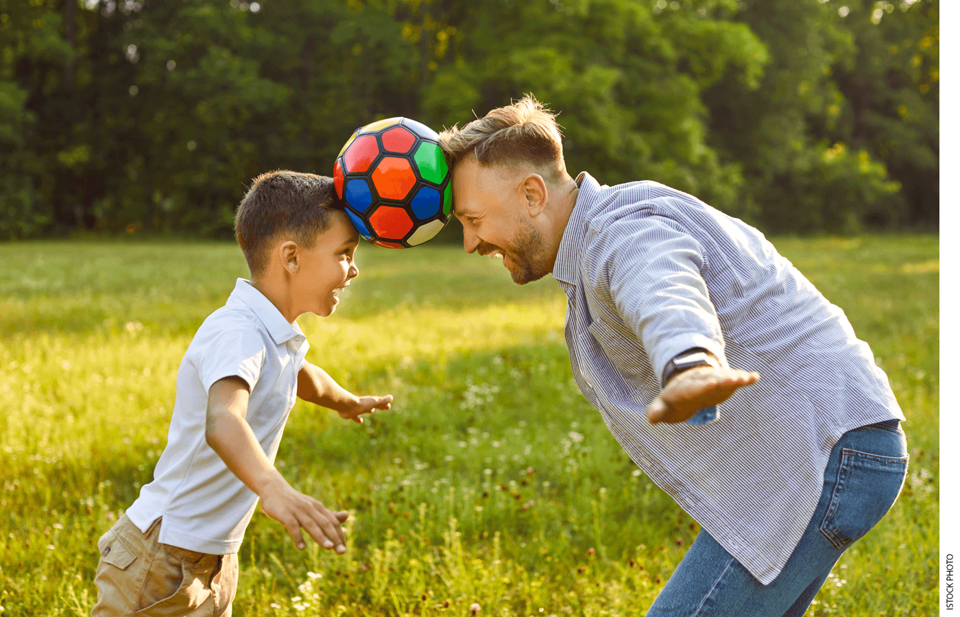 A father and son balance a soccer ball on their heads