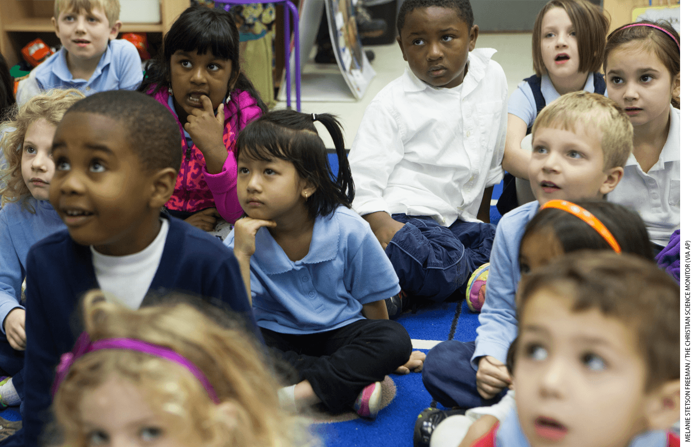 Kindergarten students at the International Community School, a public charter school in Decatur, Georgia, listen to their principal read a book.